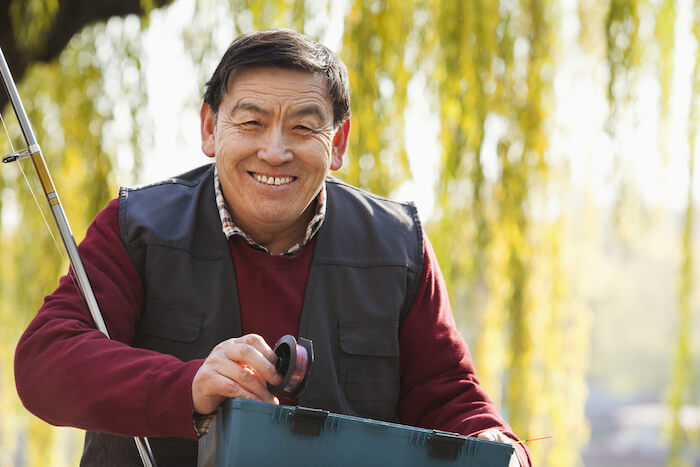 Older smiling man with fishing pole