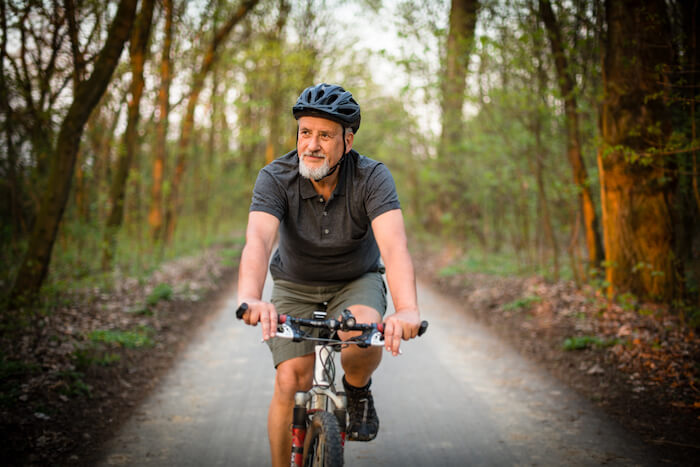 Senior man on bike in forest